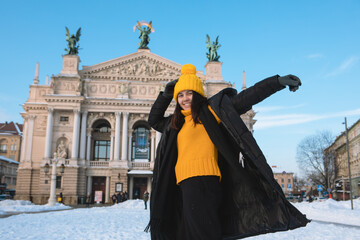 happy woman traveler in front of opera building in lviv city