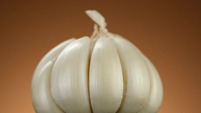 Whole garlic on brown background, rotating. Eco friendly food concept