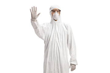 Worker in a decontamination suit gesturing stop