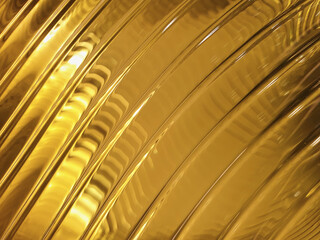 Close-up of yellow glass in light. Abstraction. Gold, yellow wave background.