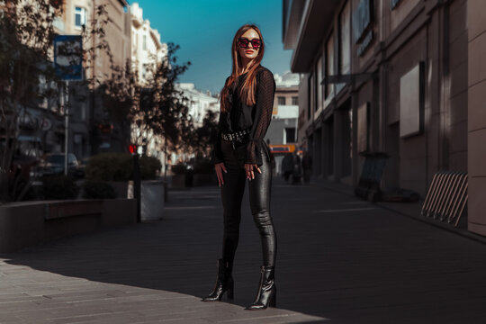 portrait of Glamour lady in leather suit and sunglasses looking away in the street