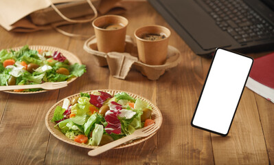 Vegetable salad with salmon. Food delivery to the office, white blank mobile phone screen