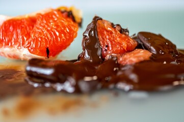 Dissolved bitter chocolate with pieces of red grapefruit, closeup
