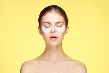 woman with bare shoulders and punchy rejuvenation skin care yellow background