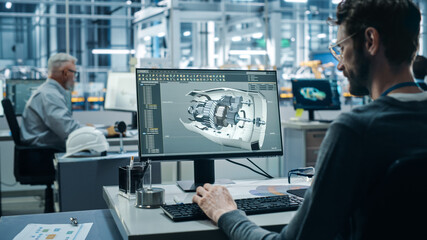 Car Factory Office: Engineer Working on Turbine Prototype on Computer, Design Advanced 3D Model for...