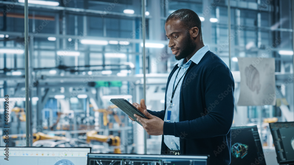 Poster car factory office: portrait of successful black male chief engineer using tablet computer in automa