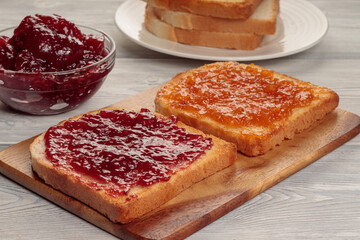 Toasts with jam on wooden board. Selective focus.