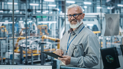 Car Factory Office: Portrait of Senior White Male Chief Engineer Using Tablet Computer in Automated...