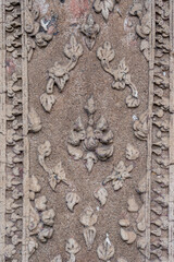 Detail of beautiful ancient stucco decor with traditional Lanna Thai floral motif on exterior of historic hor trai library in Wat Duang Dee or Duang Di, Chiang Mai, Thailand