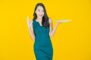 Fototapeta na wymiar Portrait beautiful young asian woman smile with empty plate dish