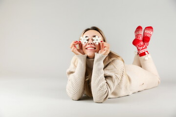 beautiful girl posing with snowflakes on a gray background. young woman wearing Christmas socks....