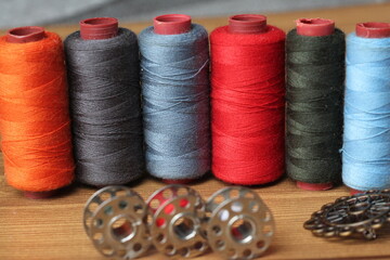 Spools of Thread, Bobbins, and Buttons on Wooden Surface – Sewing Supplies Close-Up