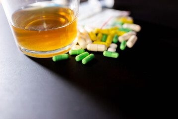 Hard drugs and alcohol on dark gray table. Alcohol pills syringe plastic bag powder of cocaine on...