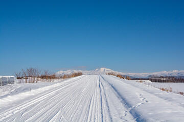 冬の晴れた日の雪道と雪山　大雪山
