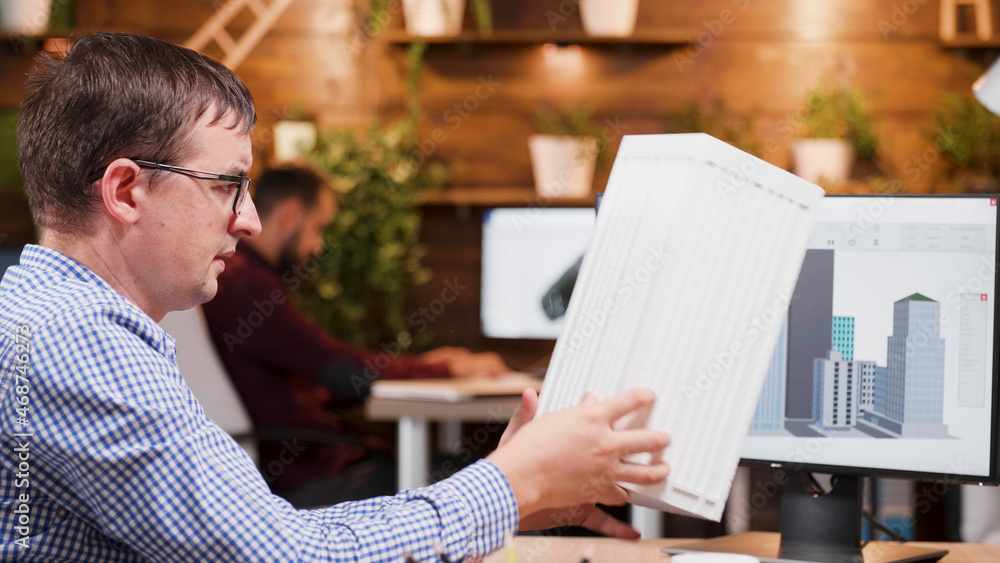 Poster focused engineer man analyzing building prototype developing technical construction working in creat