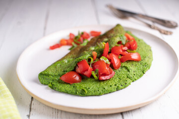 Omelet with tomatoes. Cooked with eggs and spinach