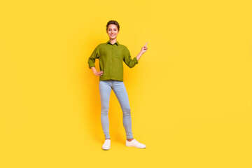 Fototapeta na wymiar Photo of promoter lady arm hip direct finger empty space wear green shirt jeans shoes isolated yellow color background