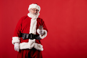 Fototapeta na wymiar Santa Claus using a mobile phone on red background
