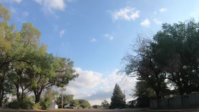 TIMELAPSE -In the middle of an empty street in a small town called Empress Alberta Canada on a sunny day with trees and buildings around.