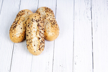 Group of seeded bread baguettes on a white wooden board. Food concept