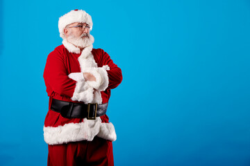 Fototapeta na wymiar Santa Claus with crossed arms on a blue background