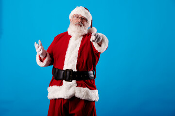 Fototapeta na wymiar Santa Claus pointing his finger at the camera on a blue background