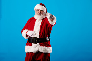 Fototapeta na wymiar Santa Claus pointing his finger at the camera on a blue background