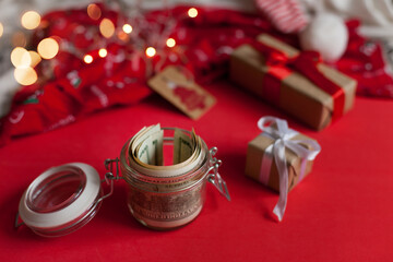 Cash money dollars  on red background near christmas gifts - christmas presents expenses