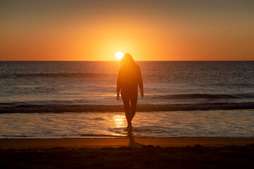 Girl walking on the shore at sunset at Los Lances beach, Tarifa, Cadiz province, Andalusia, Spain  © inigolaitxu
