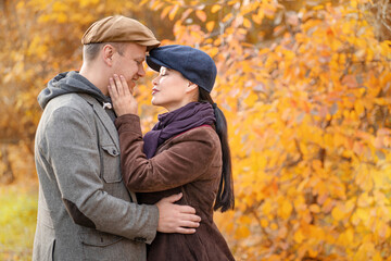 Caucasian Fall Couple Looking at Each Other's Eyes. Casual Couple in Stylish Caps in an Autumn Suburb. Close-up. Fall Background