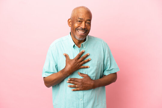 Cuban senior isolated on pink background smiling a lot