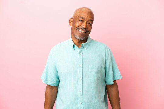 Cuban senior isolated on pink background laughing