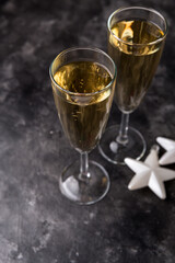 Two champagne glasses and Christmas ornaments on a black background. New year party concept