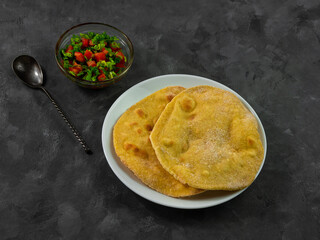 Homemade corn flatbread cilantro green tomato salsa authentic textile. Handmade mexican tortilla vegetable salad.Traditional Indian Punjabi Makki ki roti bread plate top view Wheat flour dough cuisine