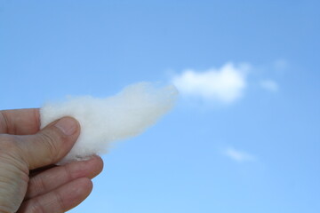 La mano que sostiene una bola de algodón que simula parte de la nube forma un hermoso diseño con...