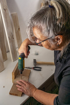 Older Woman Working In Her Workshop