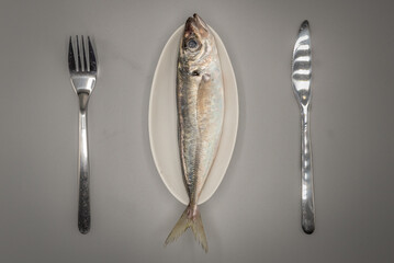 Meckerel fish on a table dish with cutlery presentation