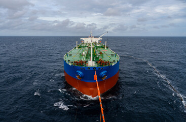 Crude oil transfer operation from floating storage of oil tanker to the export oil tanker using tandem mooring setup operation in open sea.