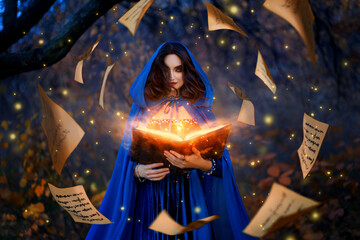 Fantasy woman witch magician in hood holds in hands magic book, bright orange light spells, wind...