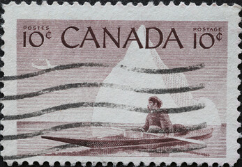 CANADA - CIRCA 1955: A postage stamp from Canada showing a native Eskimo with Inuk & Kayak