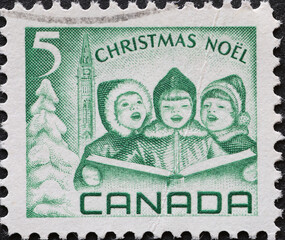 CANADA - CIRCA 1967: A postage stamp from Canada showing a Christmas postage stamp with three singers Carol Singers