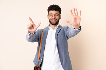 Young business Moroccan man isolated on beige background counting seven with fingers