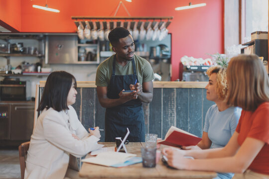waiter taking orders at the table - lifestyle cafe multiethnic people