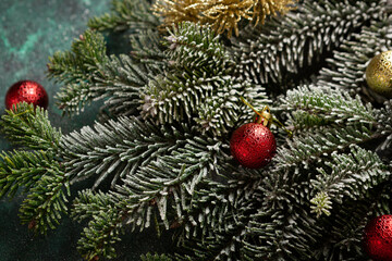 Green Christmas background with fir and decorations close up
