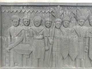 Reliefs of the life of the indigenous people of Kalimantan marching carrying traditional weapons on the walls of Central Park, North Penajam Paser Regency