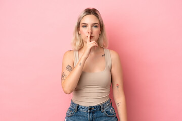 Young caucasian woman isolated on pink background showing a sign of silence gesture putting finger...