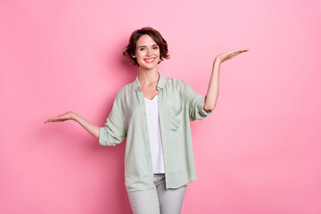 Photo of funny brunette millennial lady hold empty space wear grey green outfit isolated on pink color background © deagreez