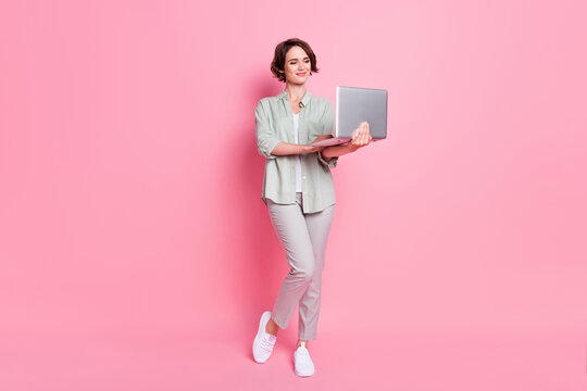 Full length photo of smart bob hairdo lady stand write laptop wear grey green cloth isolated on pink background