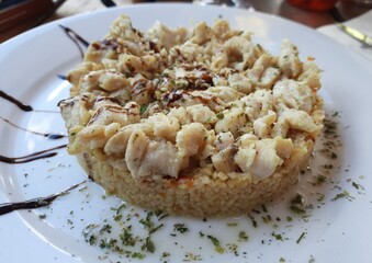 Bulgur pilaf with chicken on a white plate.  High, traditional Transcarpathian cuisine