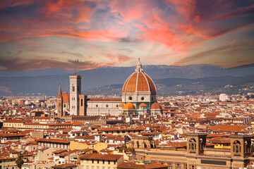 Santa Maria del Fiore cathedral in Florence, Italy. Aerial panoramic view with dome by Brunelleschi, and bell tower dominating the skyline in Tuscany, Italy. Spectacular red sunset sky background.